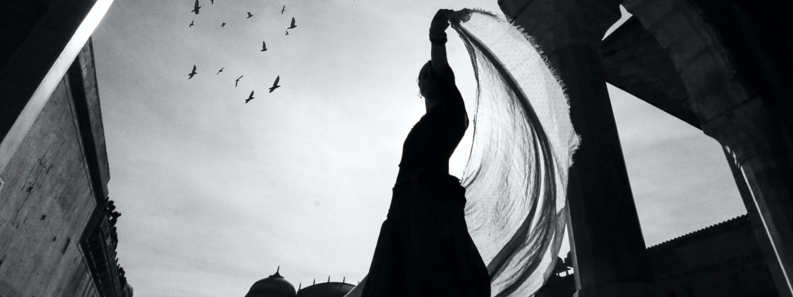 low-angle-view-of-silhouette-of-woman-standing-near-building